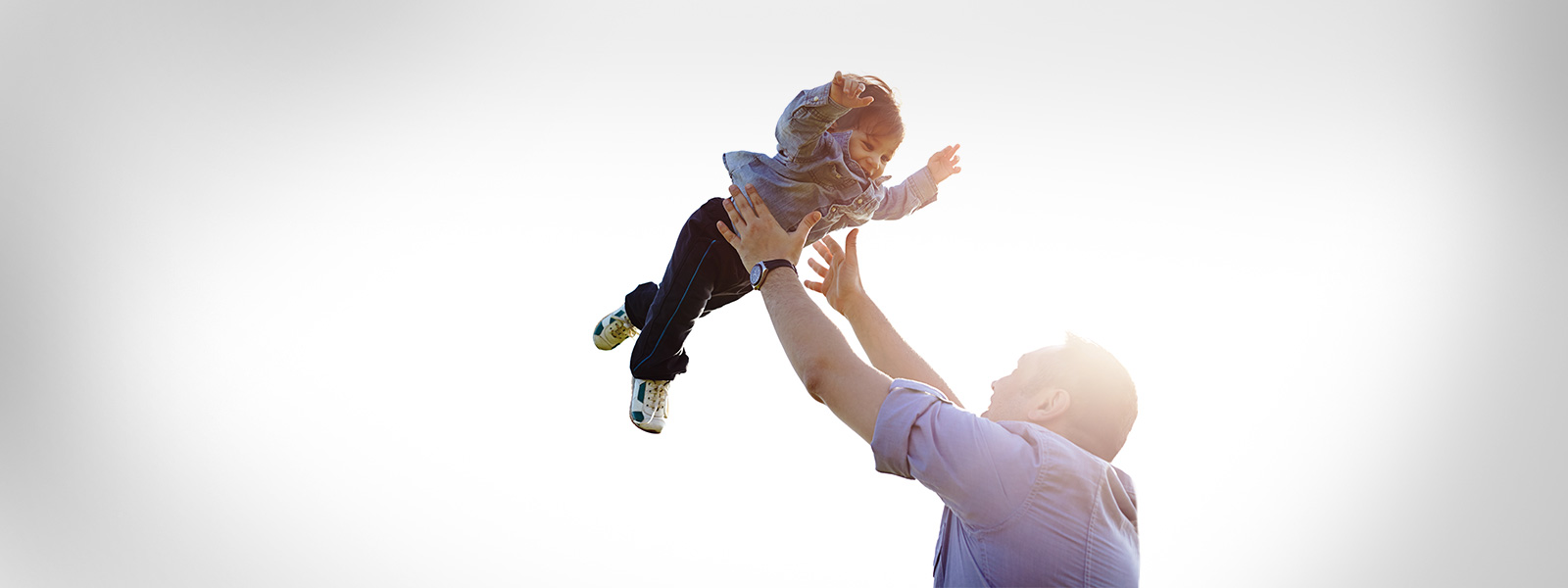 man playing with his child and throwing him in the air