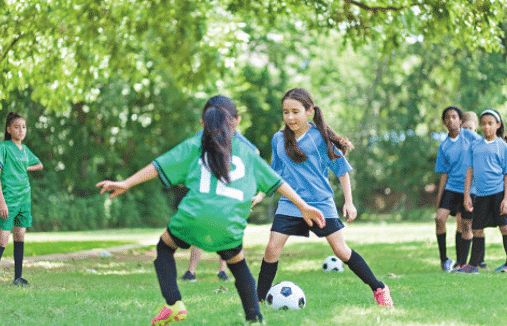 Two girls playing soccer