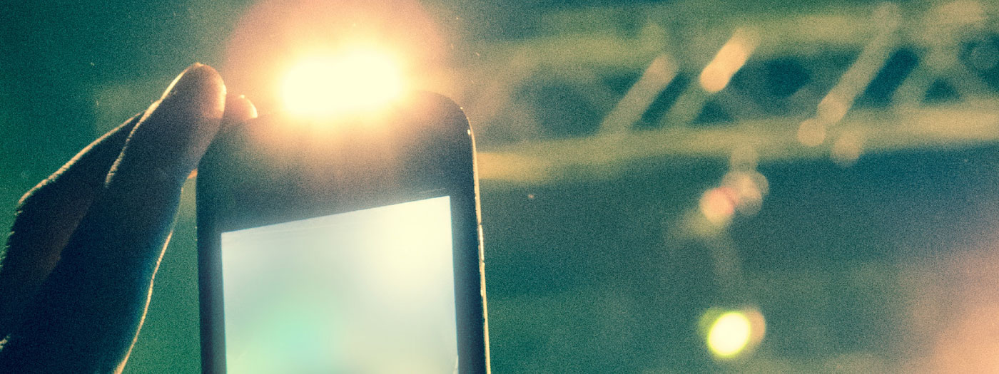 closeup of a smartphone in someone's hand, lifted to take a photo
