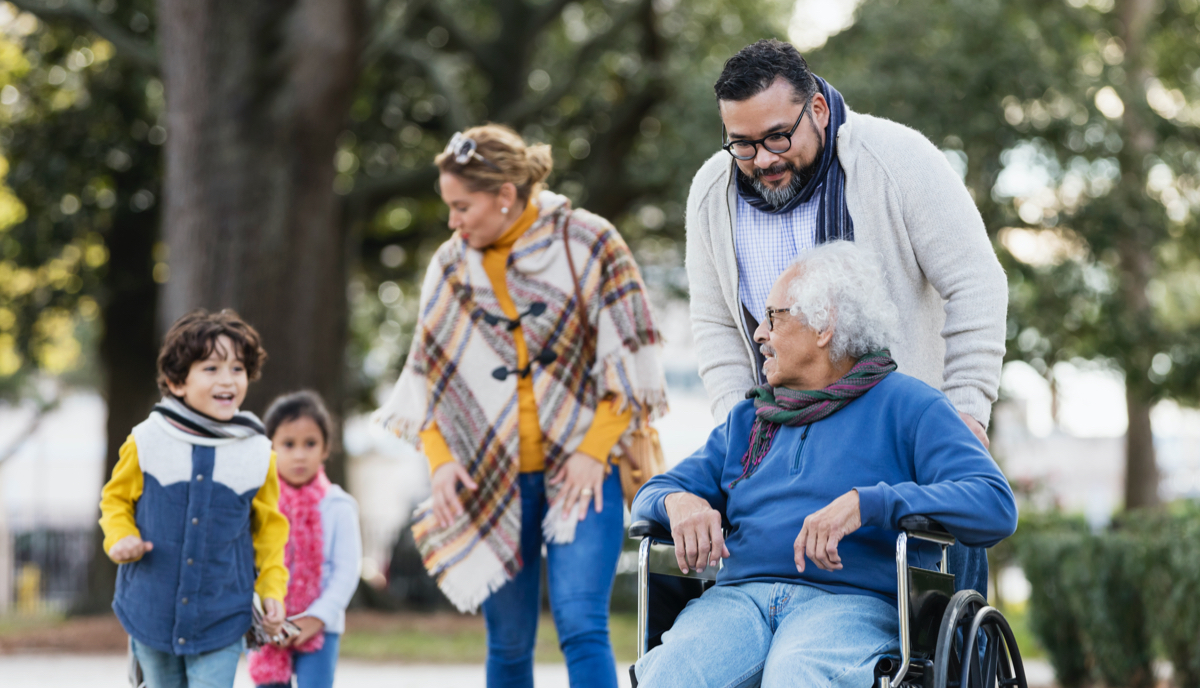 Family outdoors, including grandmother in wheelchair, parents and two children
