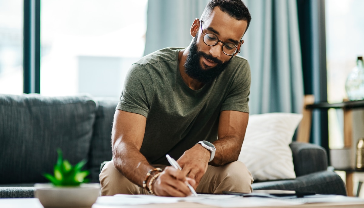 man writing on paper