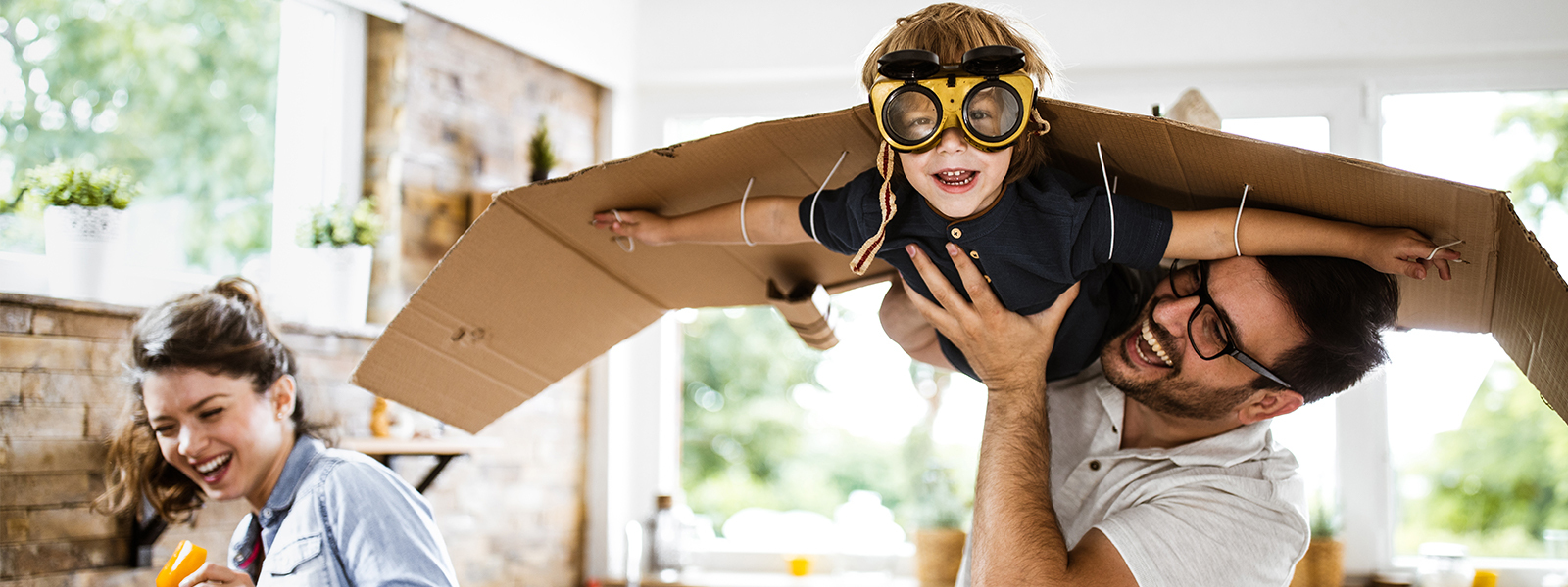 image of a father holding a child up wearing a home-made airplane
